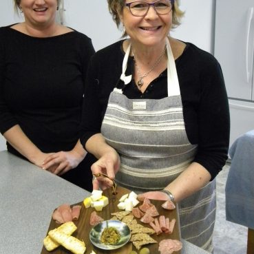 Carol Zuber with charcuterie board at "Take A Bite" festival activity
