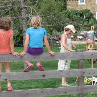 Kids on a fence watching live painting in Amana, IA